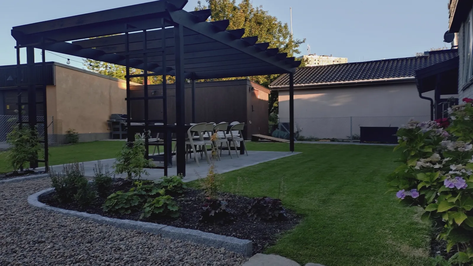 Svart pergola över uteplats